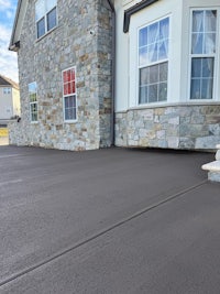 a house with a concrete driveway and a stone wall